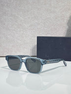 Blue sunglasses with dark lenses and patterned temple detailing