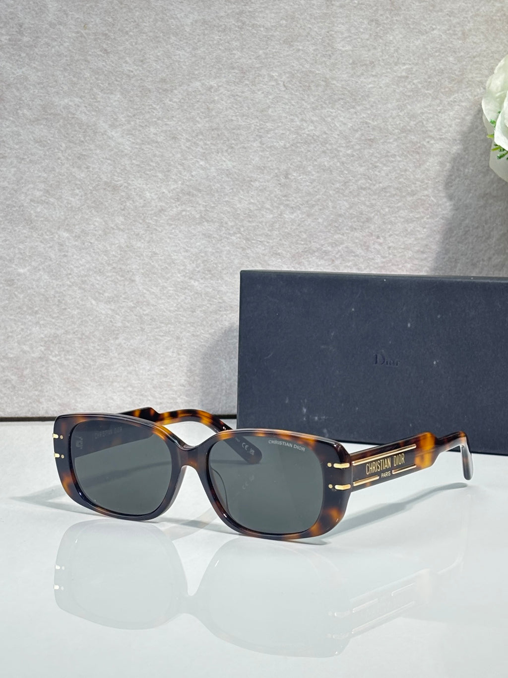 Dior tortoiseshell sunglasses with dark lenses and gold-tone logo arms