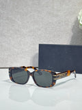 Dior tortoiseshell sunglasses with dark lenses and gold-tone logo arms