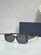 Dior tortoiseshell sunglasses with dark lenses and gold-tone logo arms