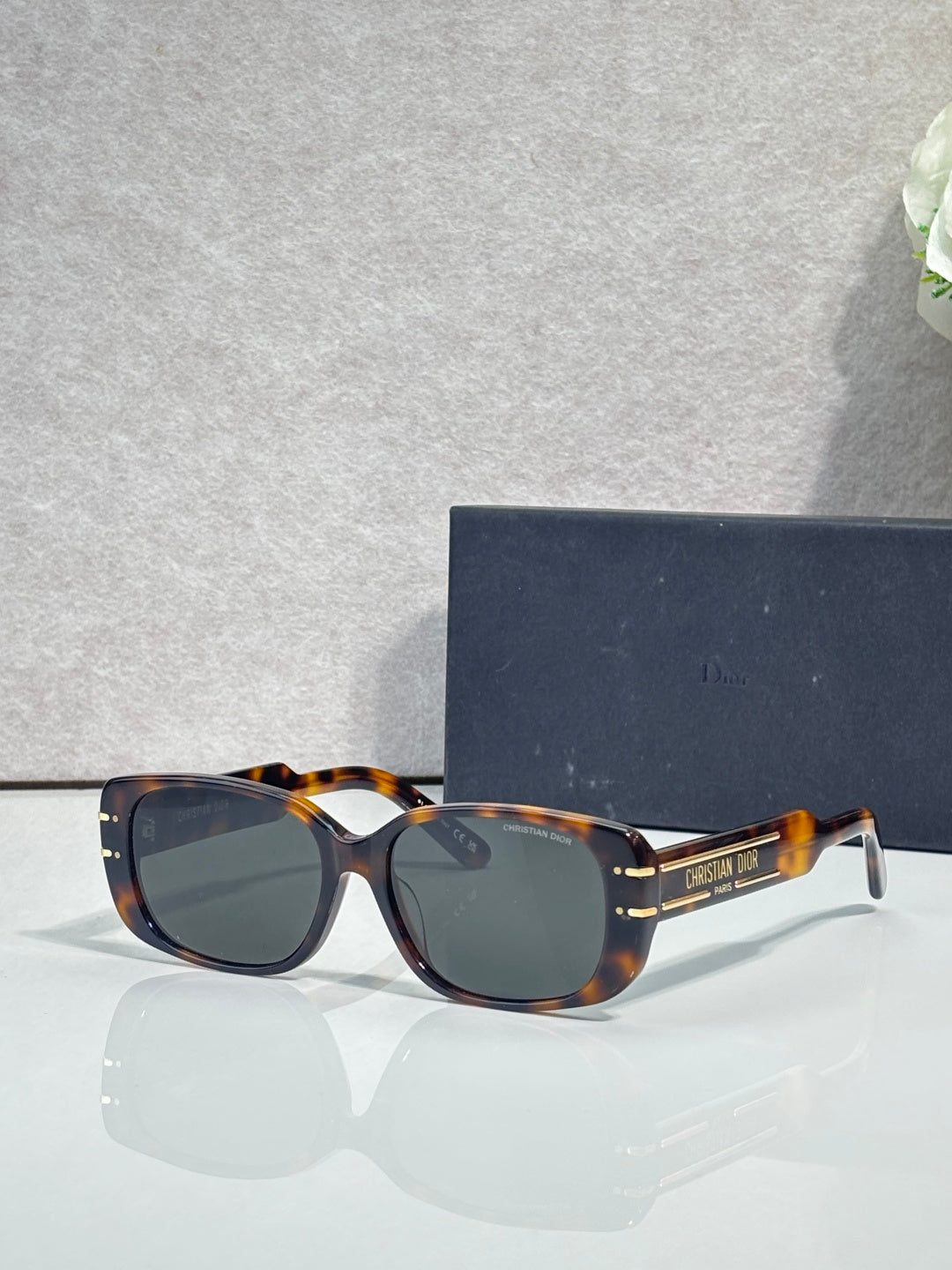 Dior tortoiseshell sunglasses with dark lenses and gold-tone logo arms