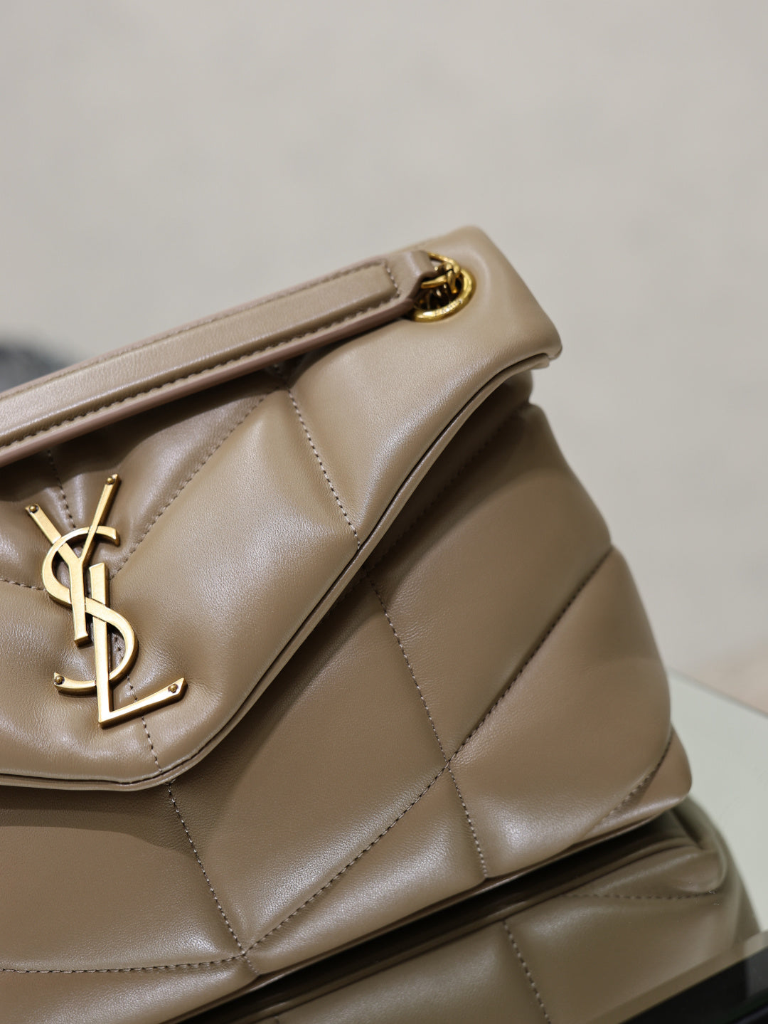 YSL beige quilted bag detail with YSL logo on the front flap