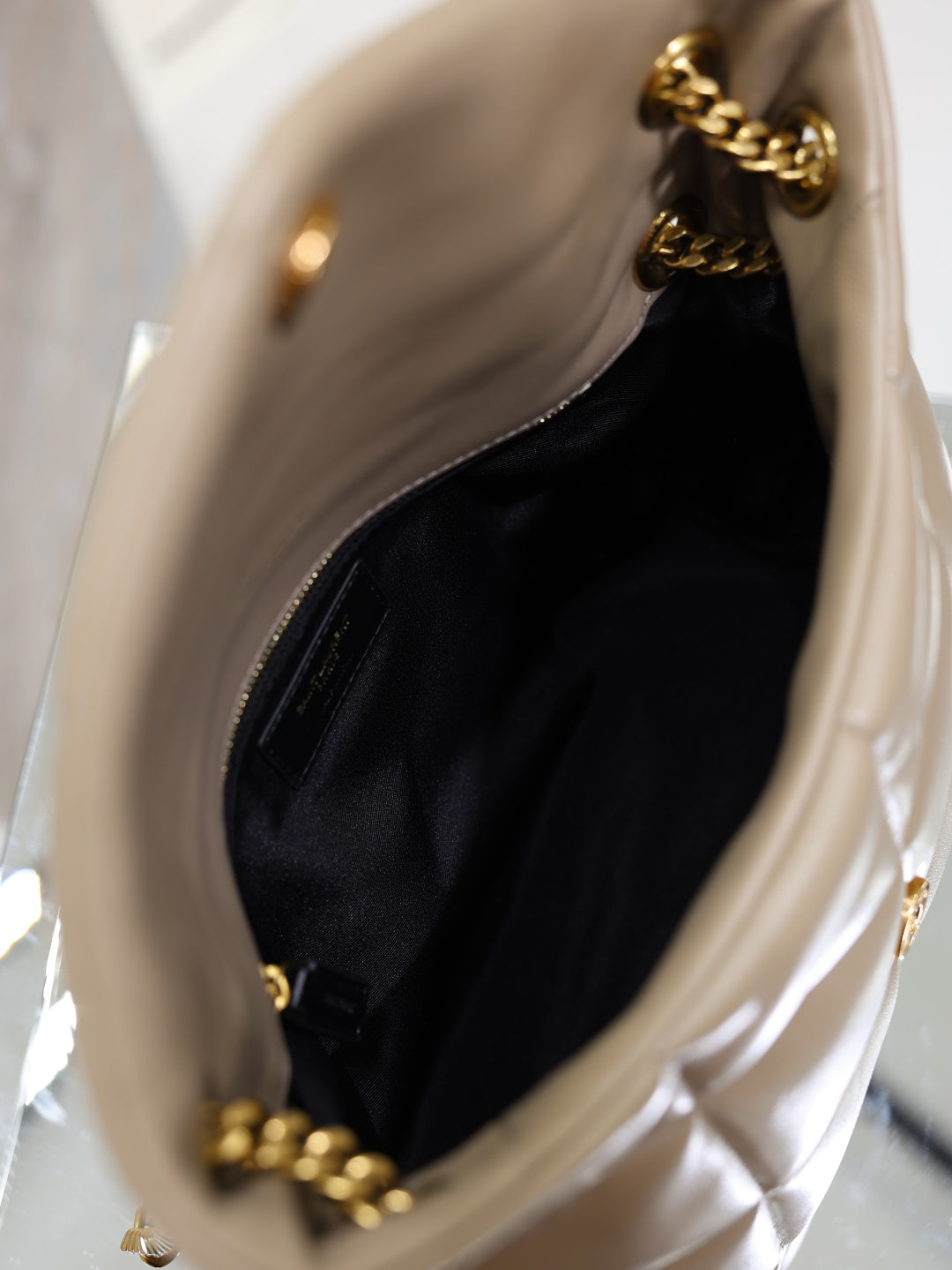 YSL beige bag interior view with black lining and gold chain trim