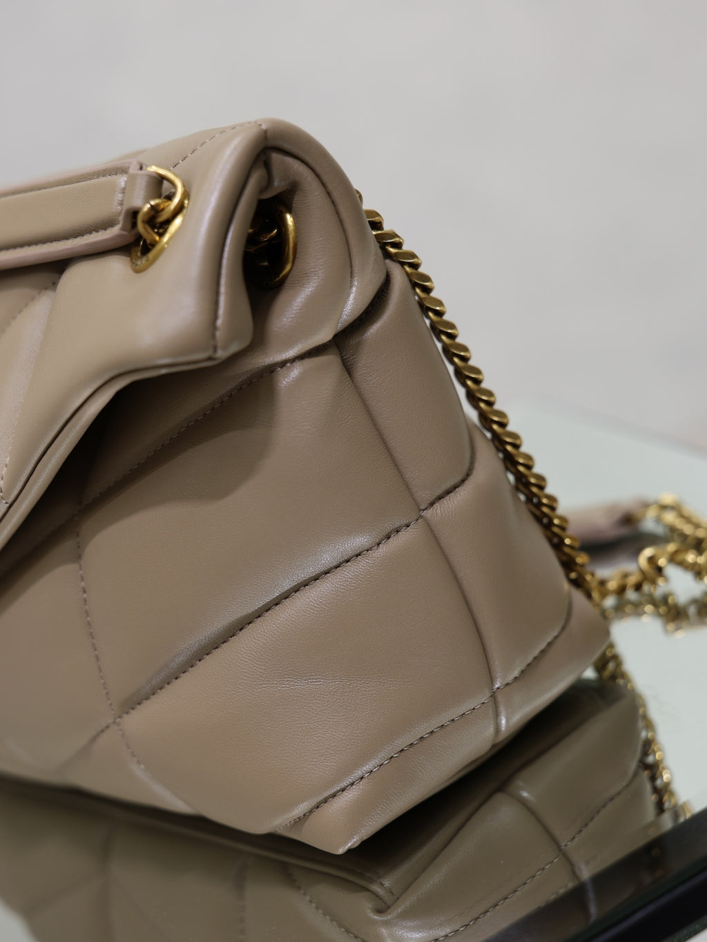 YSL beige quilted bag corner close-up with gold chain and hardware