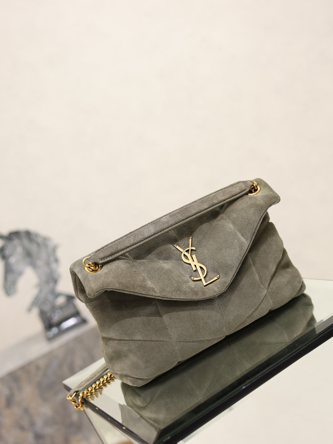 Gray YSL shoulder bag with curved flap and YSL logo, gold chain strap