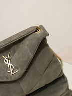 Gray YSL shoulder bag flap detail with gold YSL logo, on quilted front