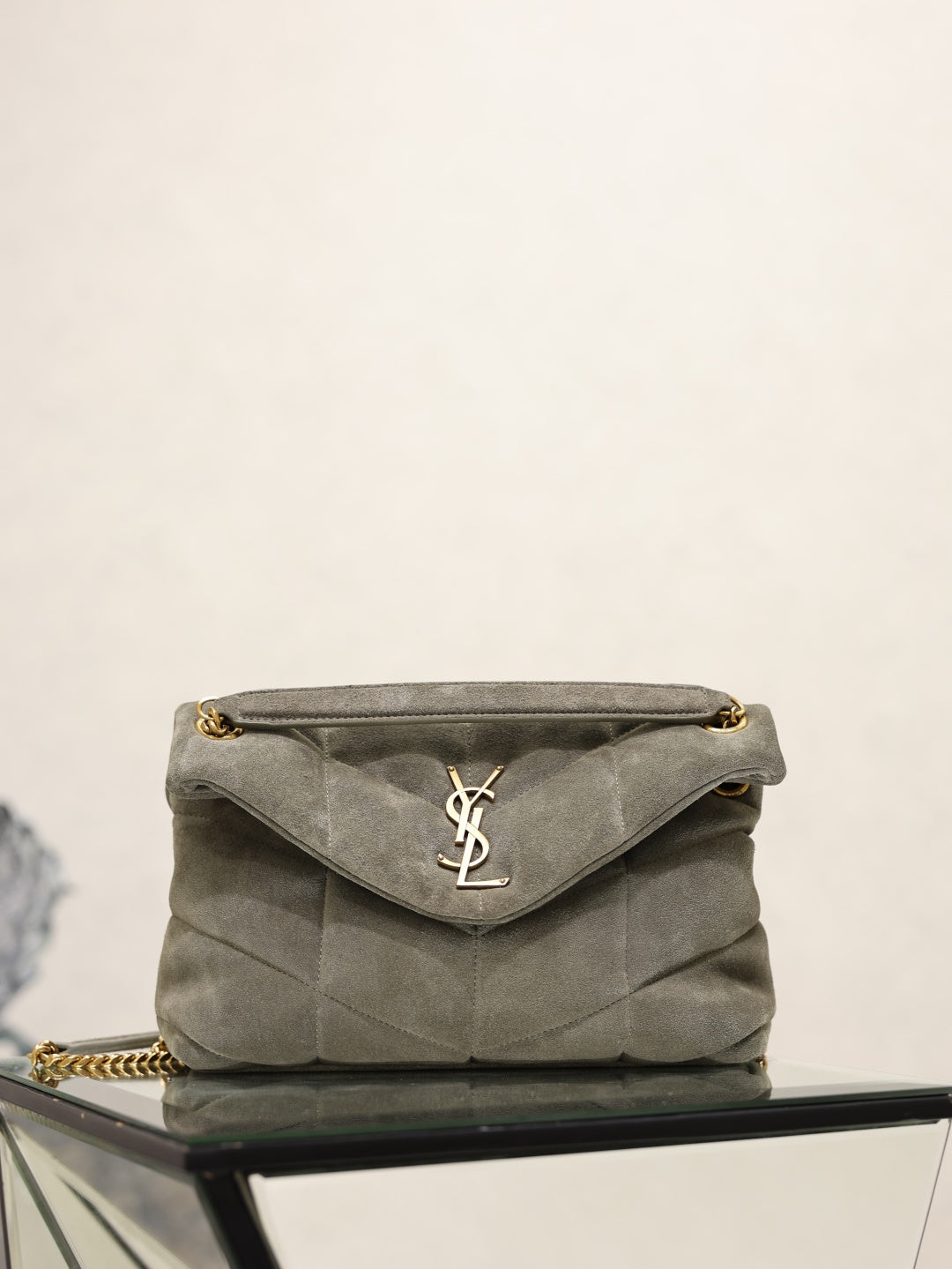 Gray YSL shoulder bag with gold chain strap and YSL logo on flap