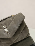 Gray suede shoulder bag flap with gold YSL logo and stitched edge detail