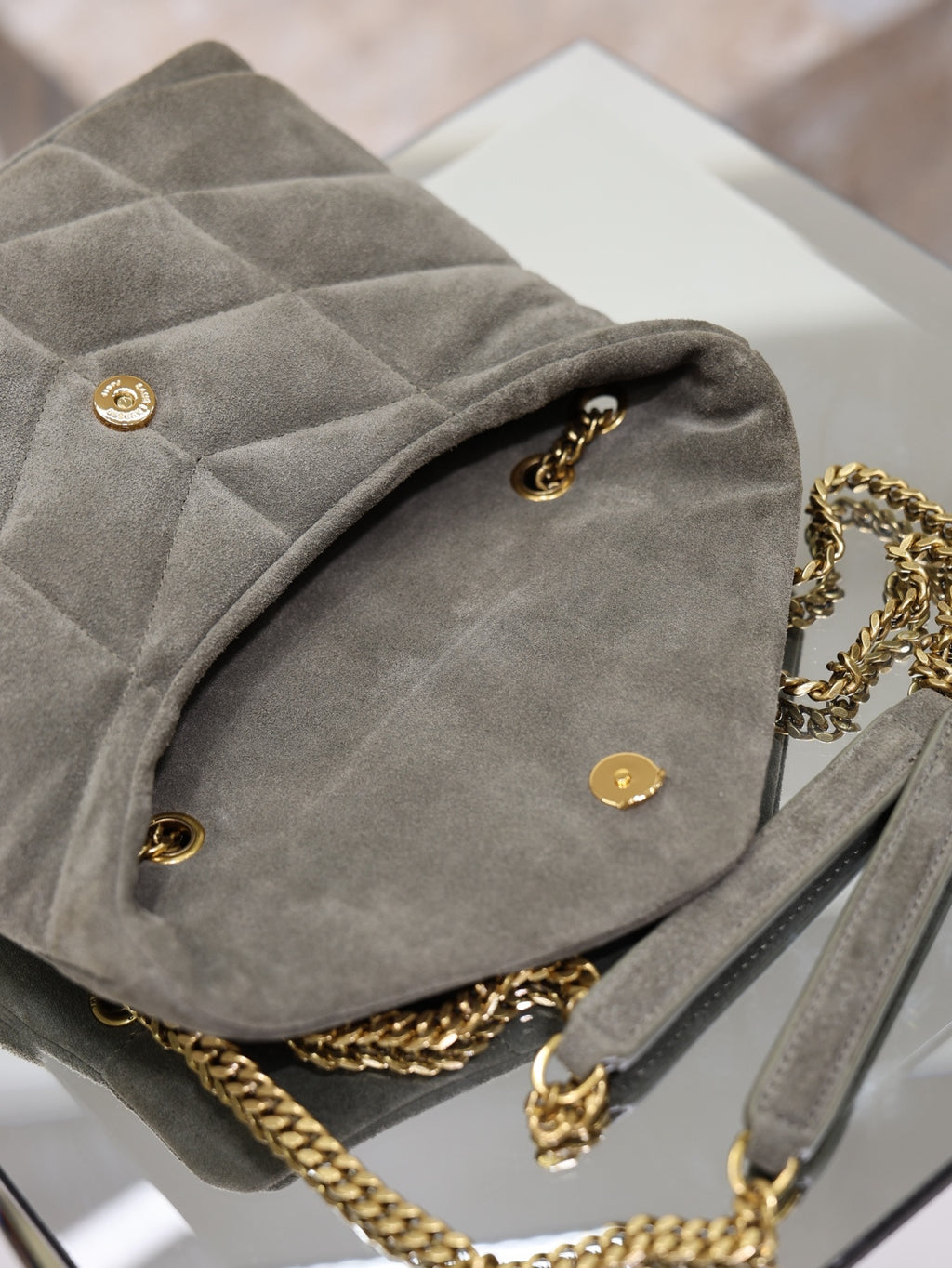 Gray suede shoulder bag with rear quilted panel, gold studs, chain strap