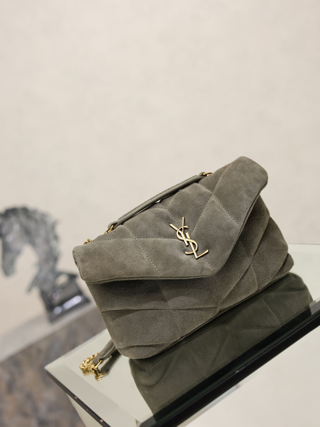 Gray suede shoulder bag with quilted flap, gold YSL logo, front 3/4 on chain