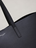 Close-up of black leather tote handle strap and textured surface