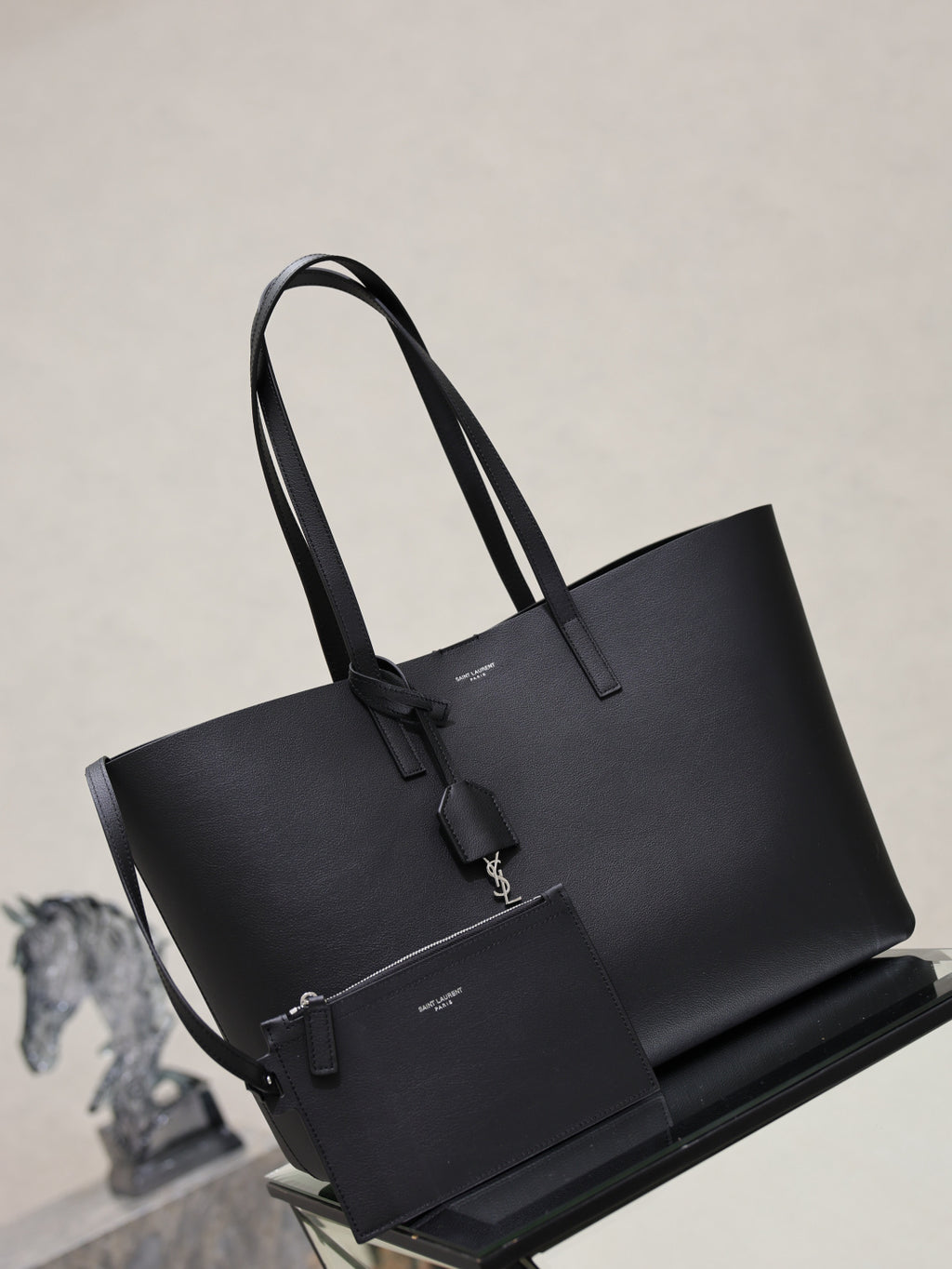 YSL black tote bag with two top handles and front hanging accessory