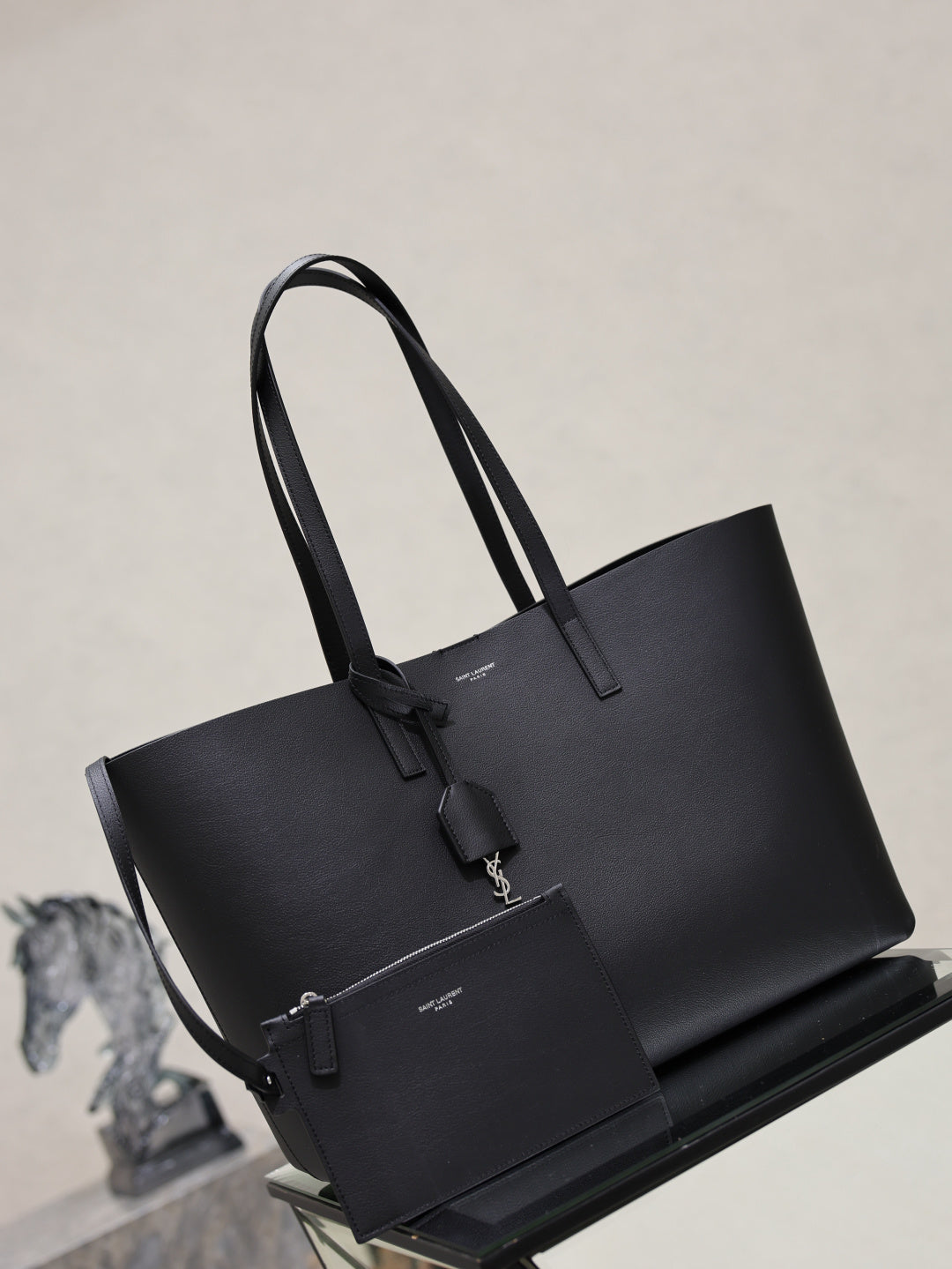 YSL black tote bag with two top handles and front hanging accessory