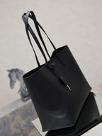 YSL black leather tote bag with top handles and attached hanging charm