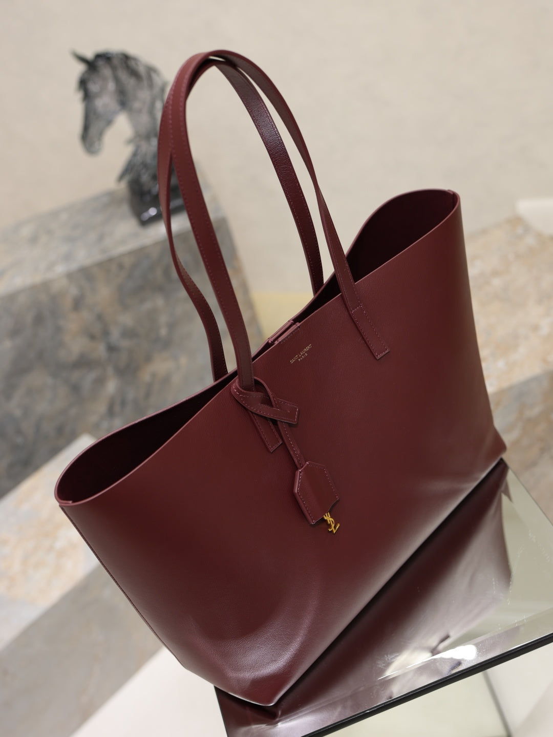 YSL burgundy tote bag with wide handles and front strap with gold logo
