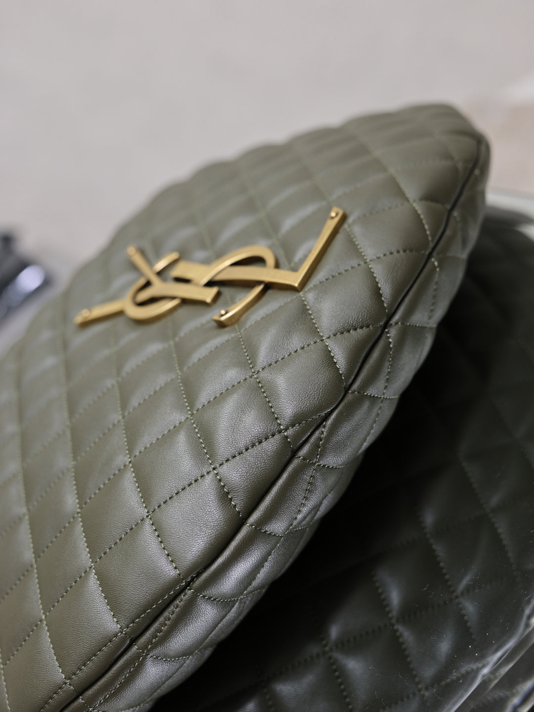 Quilted hobo bag top flap with gold YSL logo and stitching details