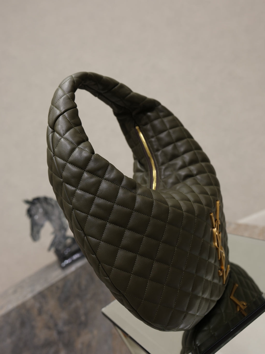 Quilted hobo shoulder bag angled view with gold zipper pulls and logo hardware