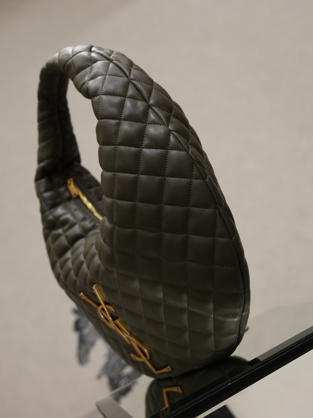 Quilted hobo shoulder bag side view with gold zipper pull and handle