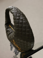 Quilted hobo shoulder bag side view with gold zipper pull and handle