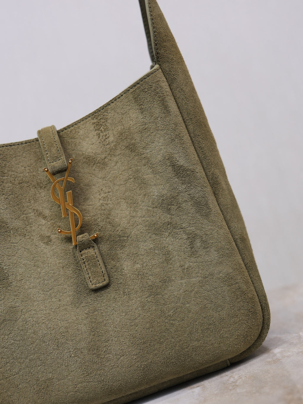 YSL bag in olive suede with YSL logo zipper pull on front pocket