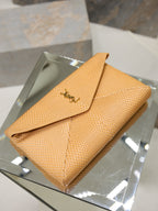 YSL envelope clutch bag on display, textured tan with flap and gold-tone logo