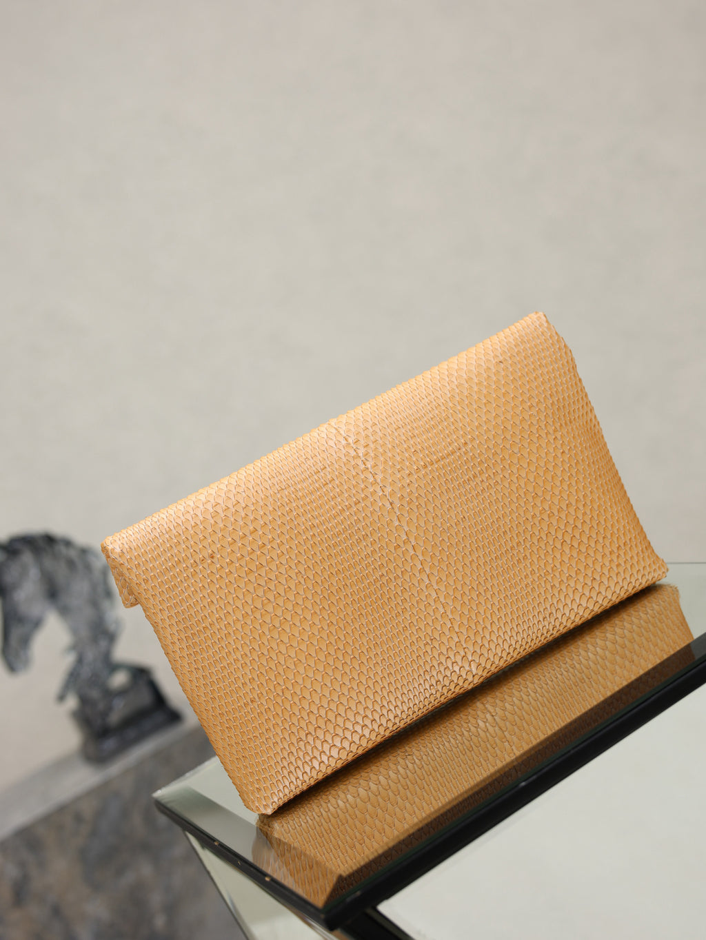 YSL envelope clutch bag top view, textured tan with folded flap and gold logo