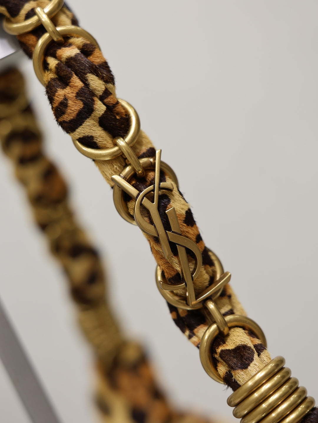 YSL bag strap detail, braided leopard-print webbing with gold-tone chain links