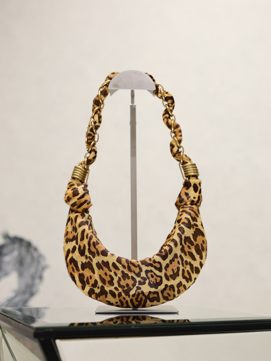 YSL bag in leopard-print hobo shape with braided chain shoulder handles and gold hardware