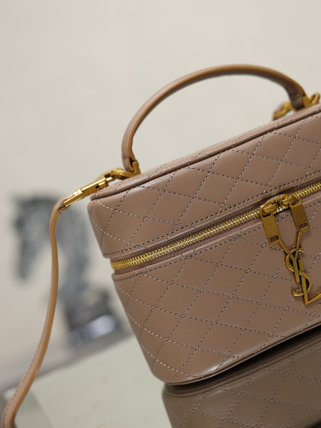 Taupe quilted mini bag corner view with zip pocket and gold-tone hardware.