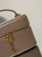 Taupe quilted mini bag close-up of top zip and gold-tone clasp hardware.