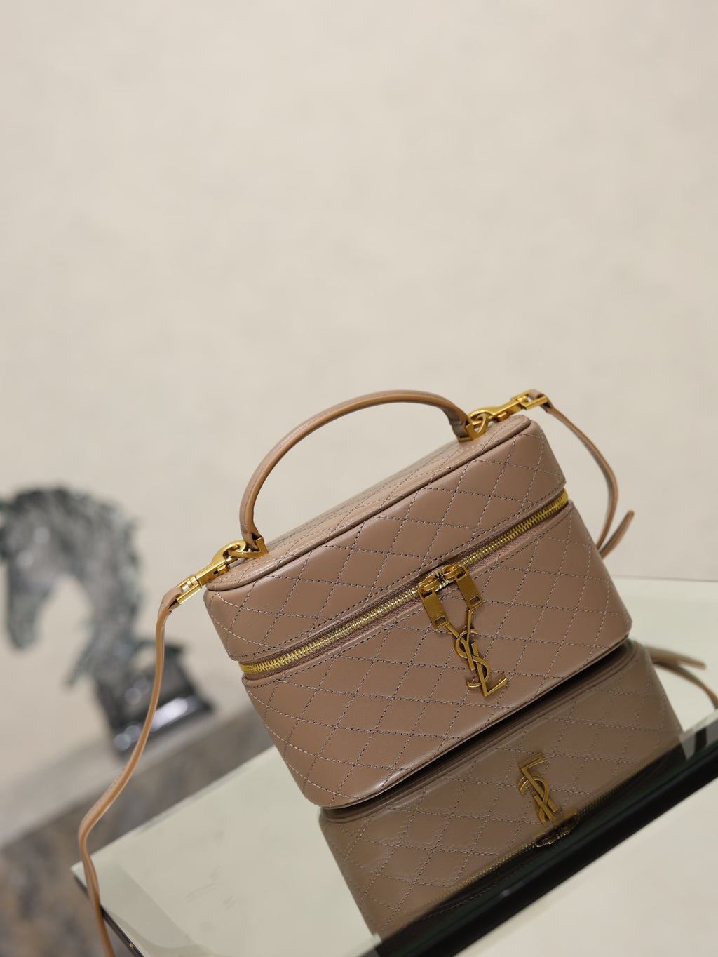 Taupe quilted mini bag with shoulder strap and flap, gold-tone YSL clasp.