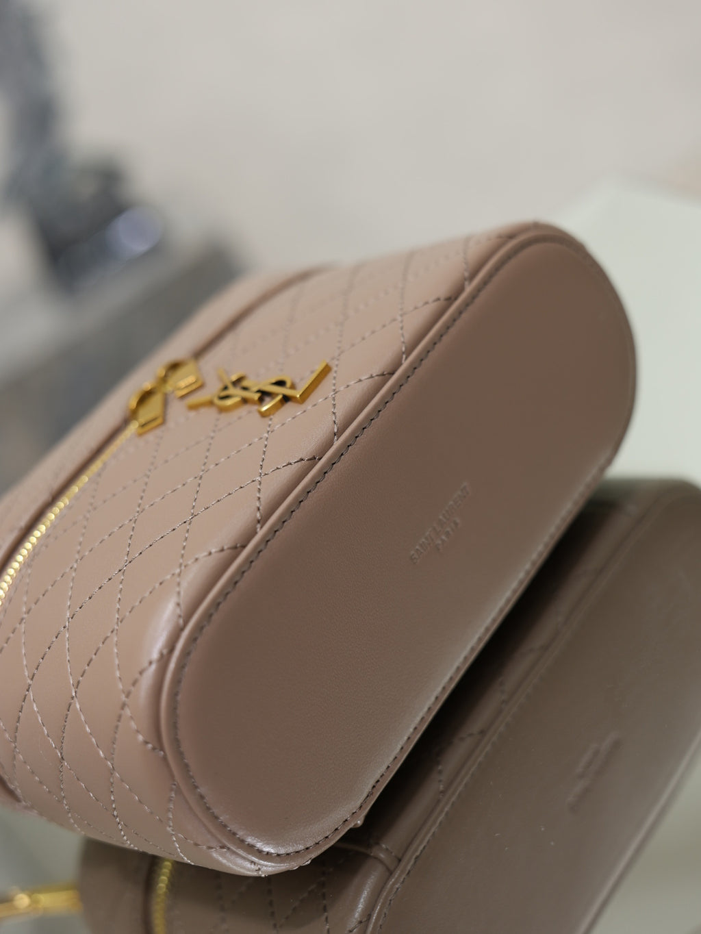 Taupe quilted mini bag back view with curved side and gold-tone YSL hardware.