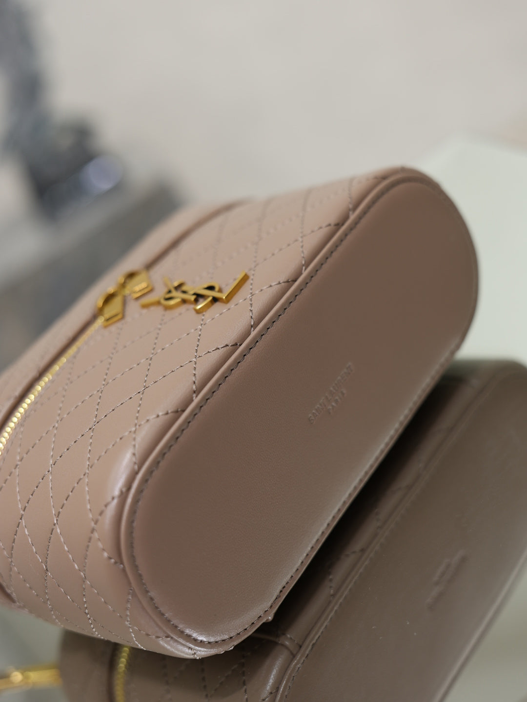 Taupe quilted mini bag back view with curved side and gold-tone YSL hardware.
