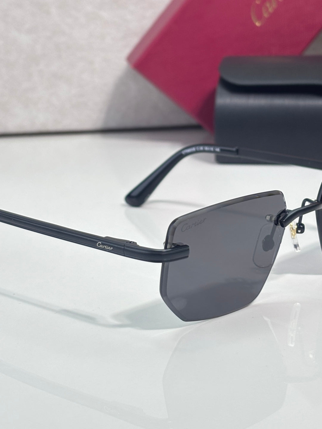 Cartier glasses close-up: dark temple with gold bridge detail and gray tinted lens