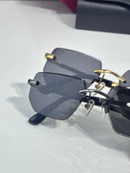 Cartier glasses on display, showing stacked frames with dark arms and gray tinted lenses