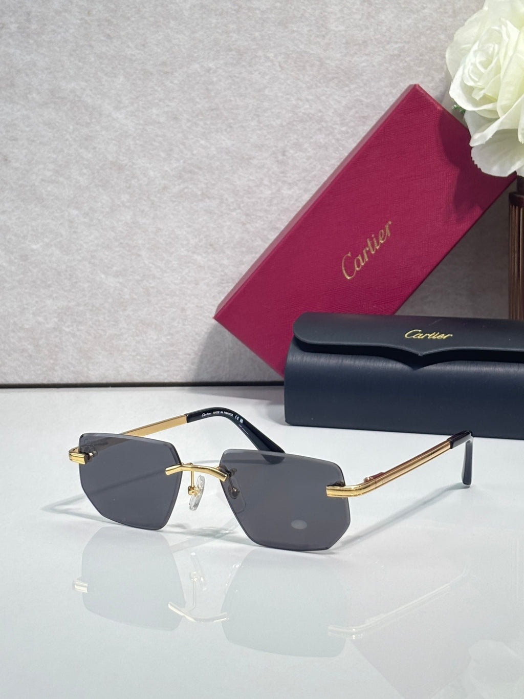 Cartier glasses with dark frames, gold metal accents, and gray tinted lenses