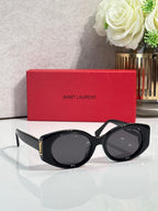 Black cat-eye sunglasses with dark lenses and gold YSL logo on the side arms