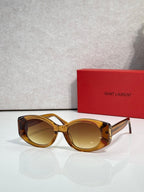 Amber tortoiseshell cat-eye sunglasses with warm gold lenses and gold YSL logo