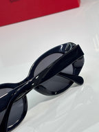 Cat-eye sunglasses with glossy black frames, side profile