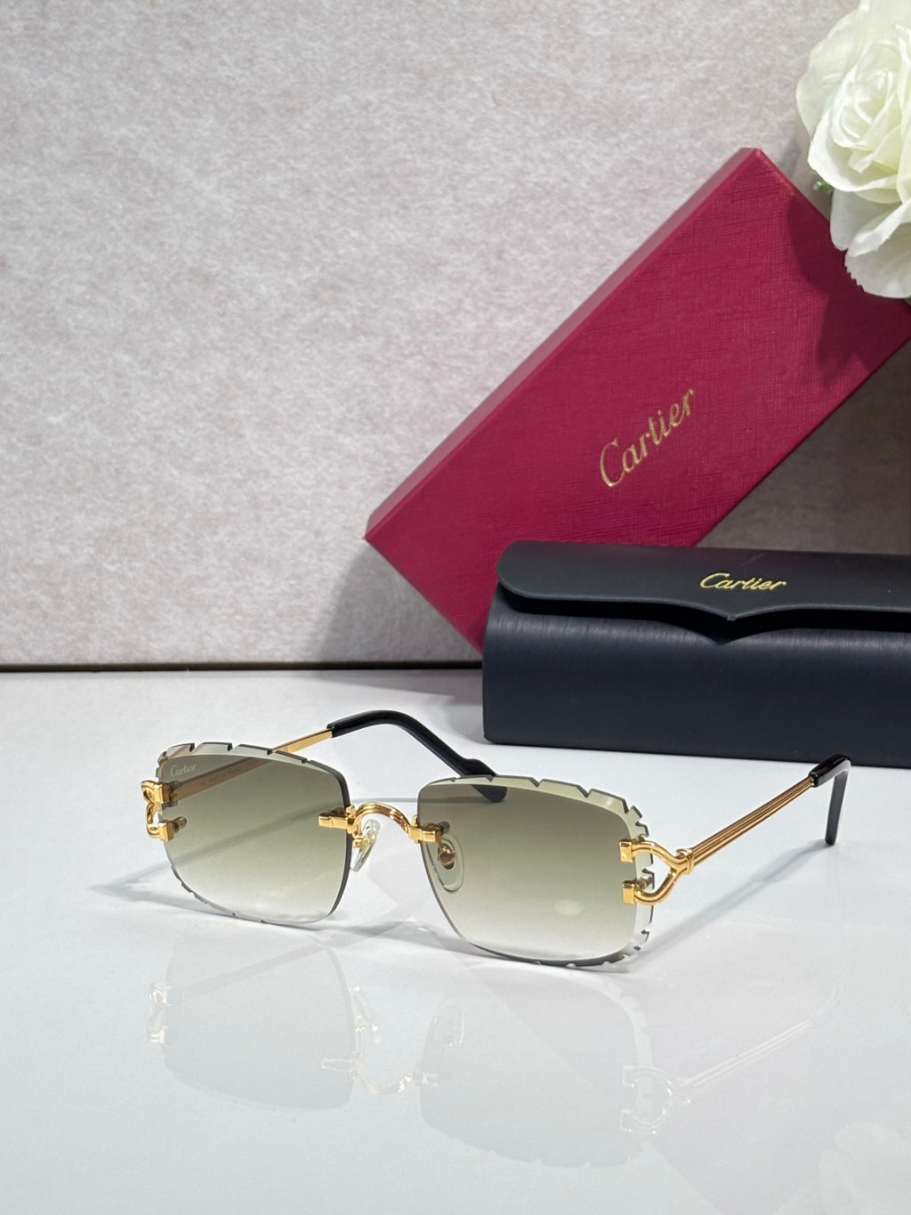 Cartier eyeglasses with gold metal frame, dark arms, and pale green-tinted lenses