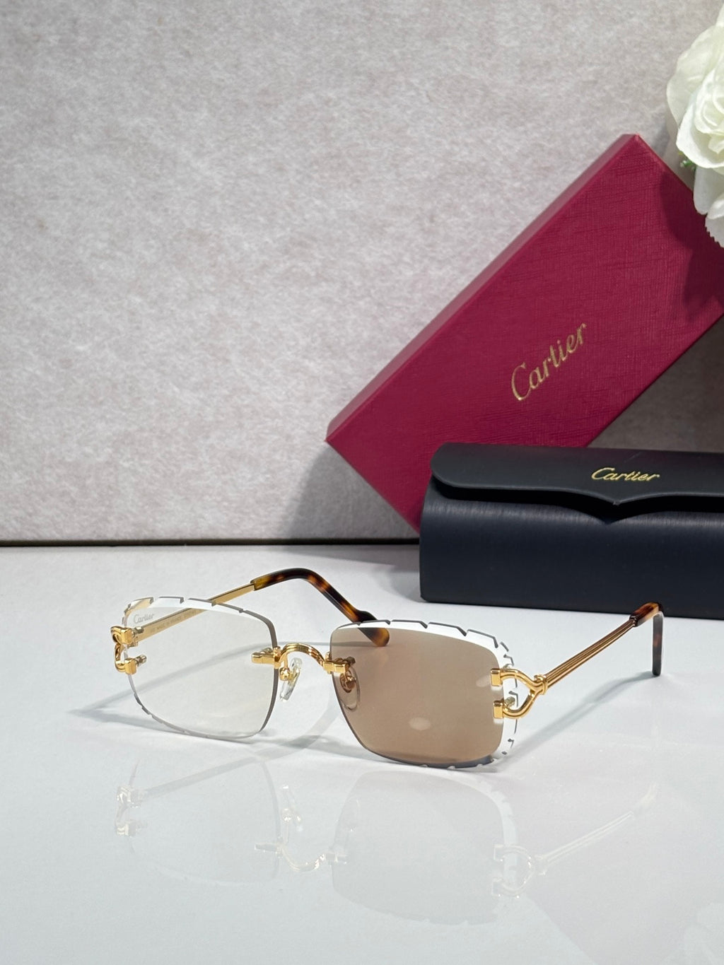 Cartier eyeglasses with gold metal frame, dark arms, and brown-tinted lenses
