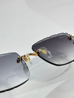 Eyeglasses with dark frame, gold hinge details, and smoky gray lenses