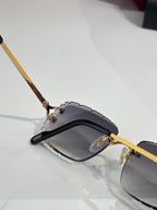 Side view of dark eyeglasses with gold temple hardware and gray lenses