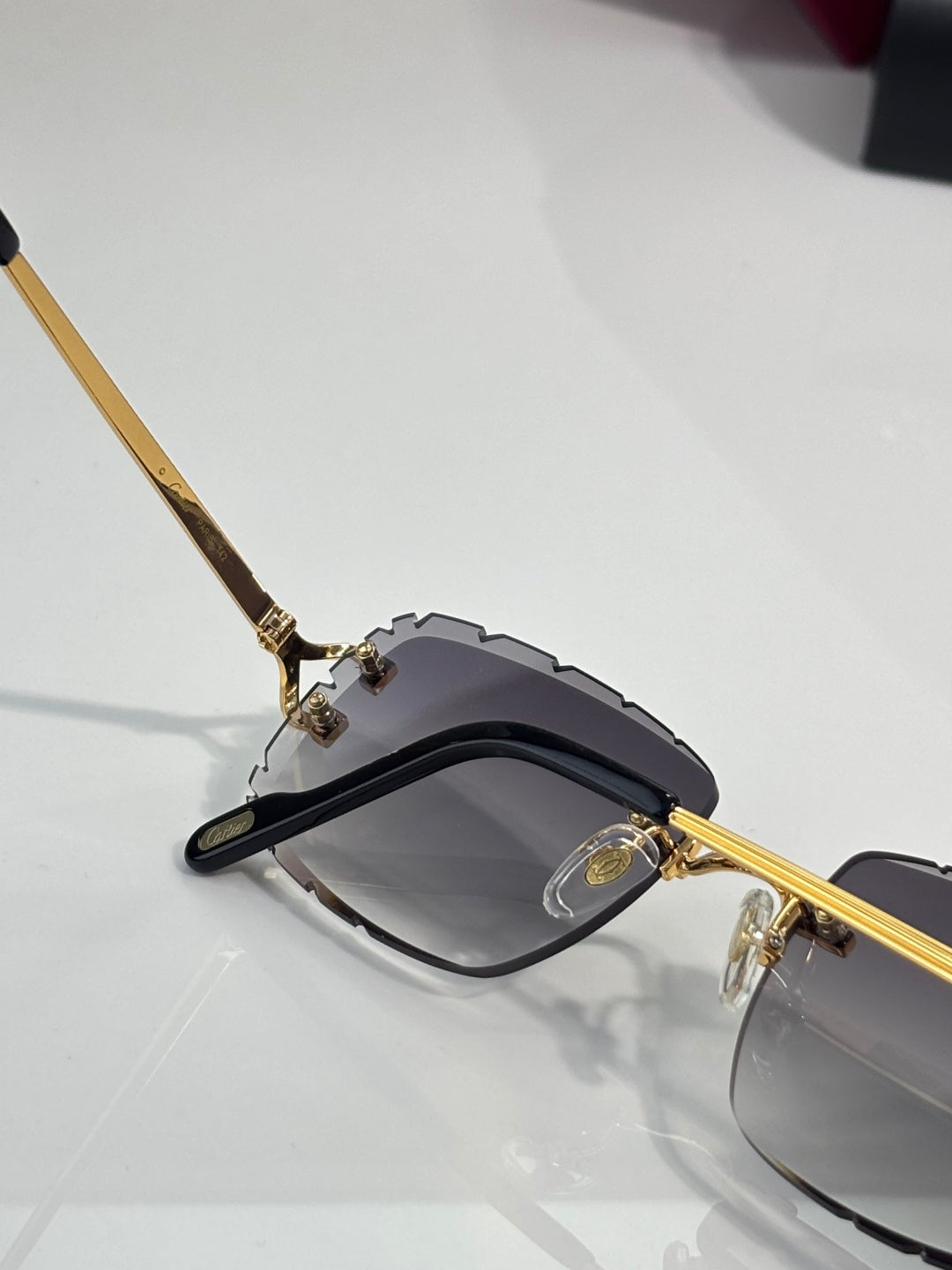 Side view of dark eyeglasses with gold temple hardware and gray lenses
