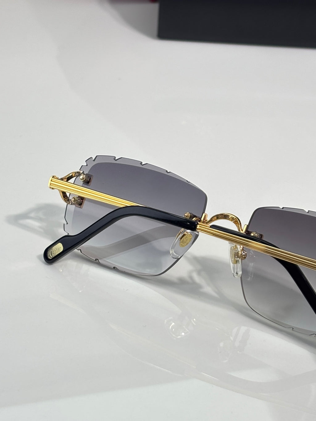 Dark eyeglasses with gold bar temples and gray gradient lenses
