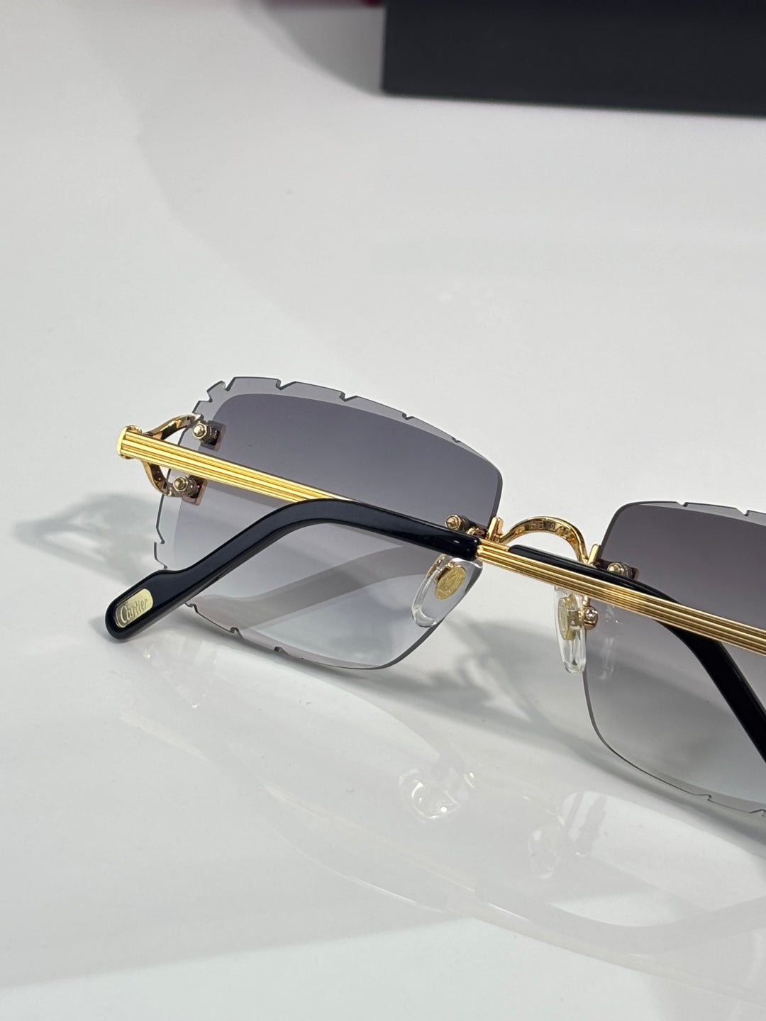 Dark eyeglasses with gold bar temples and gray gradient lenses