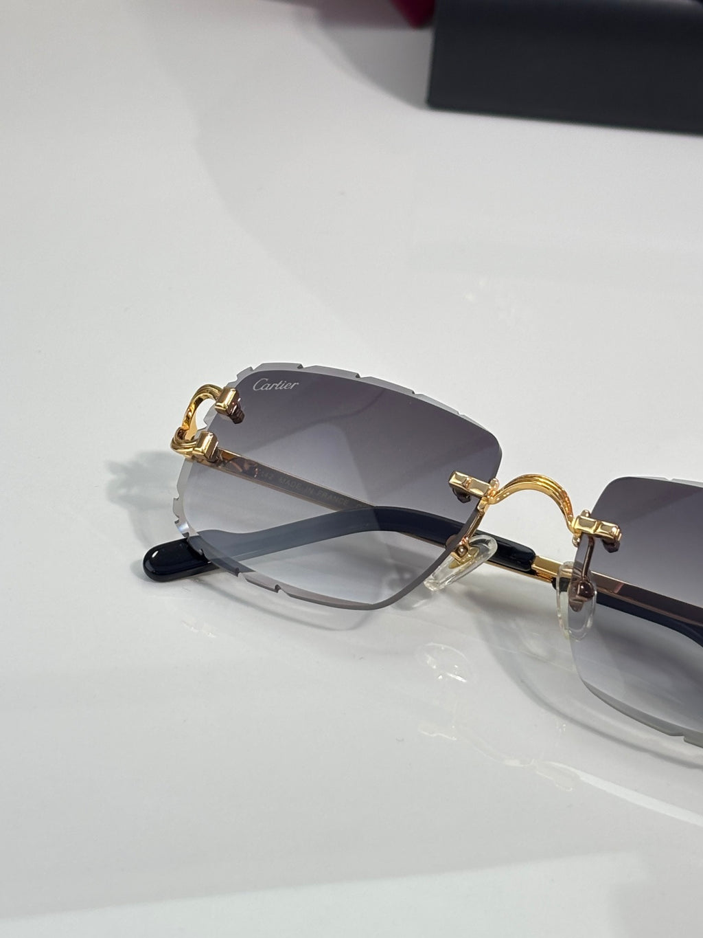 Dark rectangular eyeglasses with gold hinges and tinted gray lenses