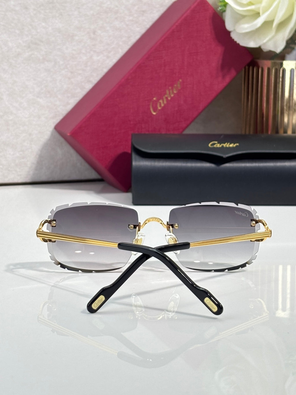 Cartier eyeglasses with black frame and gold-tone accents, gray tinted lenses