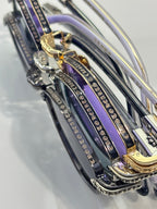 Round sunglasses close-up showing metal temples with engraved logos