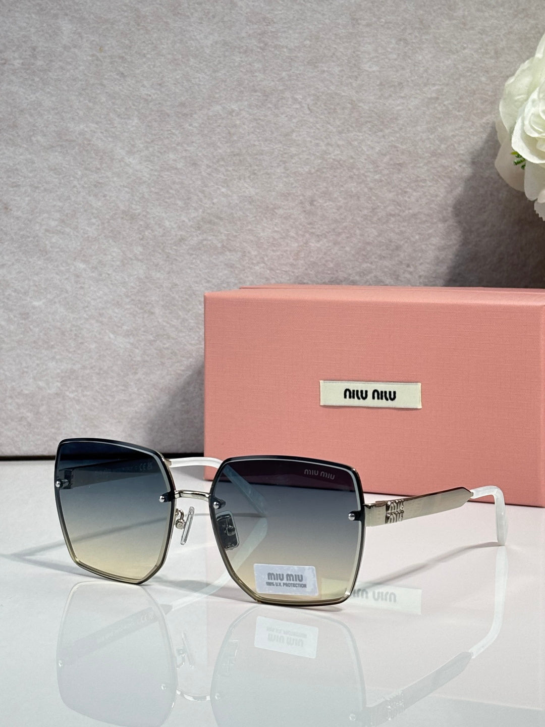 MiuMiu square dark blue glasses with blue gradient lenses and gold-tone temples